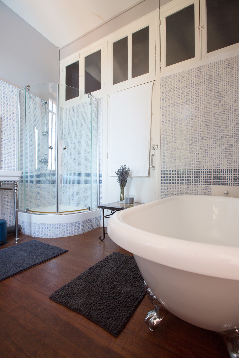 Bathroom with a roll-top bath, mosaic tiles and a corner shower