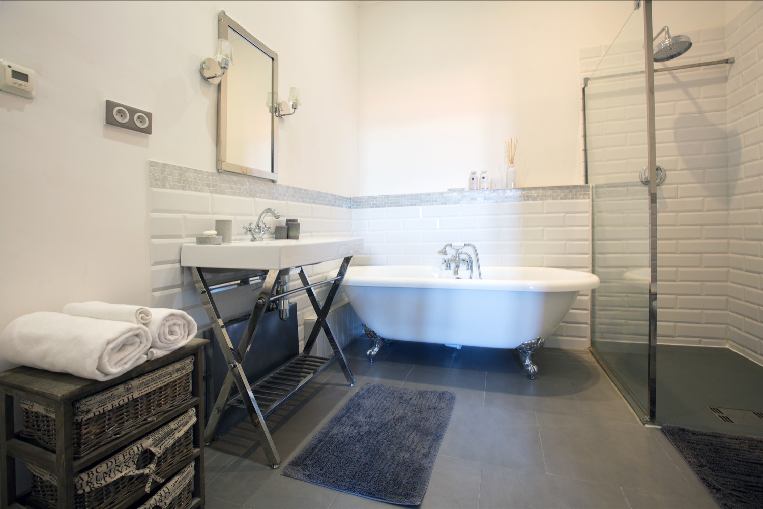 White-tiled bathroom with a claw-foot bath and a glass shower