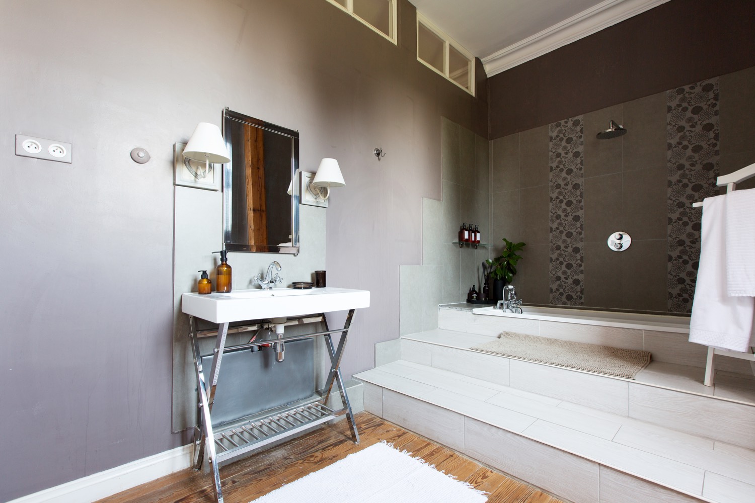 Bathroom with a raised walk-in shower, patterned tiles and a washstand