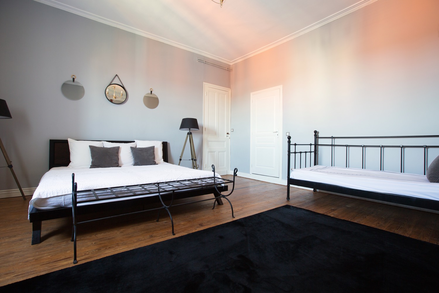 Bedroom with a double bed, a single bed and pale grey walls