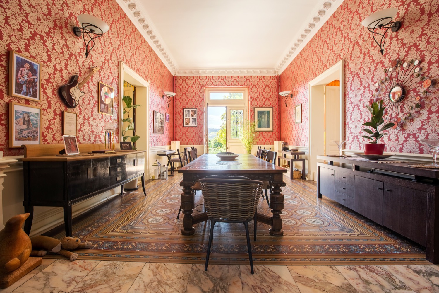 Dining hall with red damask walls, marble floor and a long wooden table