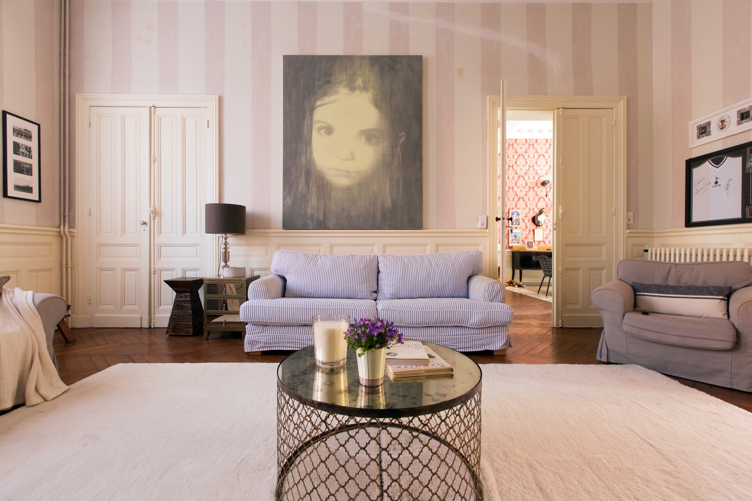Sitting room with lilac sofas, striped walls and a large portrait painting